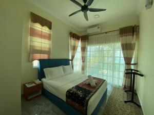 ein Schlafzimmer mit einem Bett und einem Deckenventilator in der Unterkunft Che Beach House in Kampong Ru Sila