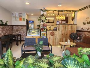 a restaurant with chairs and tables and plants at Ralik Hostel in Naga