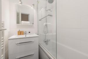 un bagno bianco con doccia e lavandino di Chamonix Sud - Grepon 102 - Happy Rentals a Chamonix-Mont-Blanc