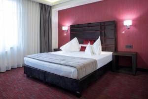 Ein Hotelzimmer mit einem großen Bett und roten Wänden in der Unterkunft Old Town Hotel in Timişoara