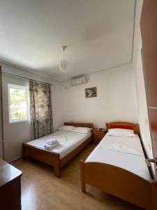 a room with two beds and a window at Keivi Guesthouse in Sarandë