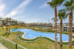 a swimming pool with palm trees in a resort at Izabell in Finestrat