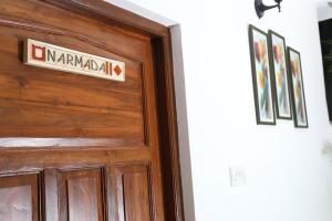 a wooden door with a sign on it at Villa Baywalk Goa - 200 meters from Morjim Beach in Morjim