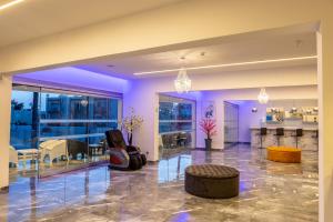 un salon avec un éclairage violet et un bar dans l'établissement Milea Hotel, à Ayia Napa