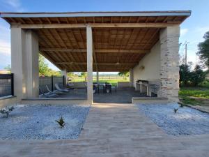 a covered patio with a table and chairs at Chambre Le Ka-Marrant in Les Pujols