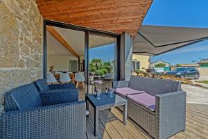 a patio with two chairs and a table on a deck at Villa Léonie - piscine intérieure in Kerlouan