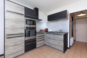 a kitchen with wooden sliding doors and a stove at MimiZen - Vue sur locéan la plage de la Garluche in Mimizan