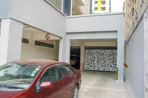 a red car parked in front of a garage at Executive Studio Apartment in Kilimani, Nairobi in Nairobi