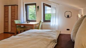 a bedroom with a bed and a desk and a table at Fewo Jörges in Obernhausen