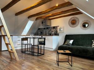 a living room with a green couch and a table at Cocon sous les toits du Gévaudan in Marvejols