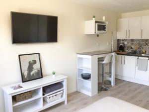 a kitchen with a tv on a wall at Studio La Rochelle-Ré in La Rochelle