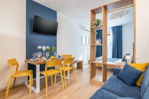 a living room with a dining room table with a blue couch at Taro's Blue Sea Apartment by Pleiades Home in Marina di Pisa