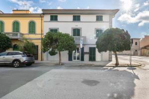 a car parked in front of a white building at Taro's Blue Sea Apartment by Pleiades Home in Marina di Pisa