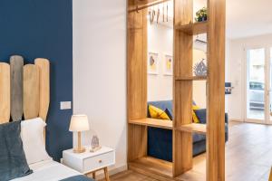 a bedroom with a large wooden mirror next to a bed at Taro's Blue Sea Apartment by Pleiades Home in Marina di Pisa