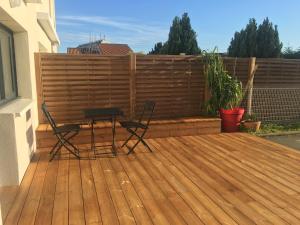 拉罗谢尔Studio La Rochelle-Ré的木甲板上配有两把椅子和一张桌子