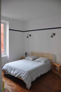 a bedroom with a bed and a white wall at Appartement Terrasse Plage in Biarritz