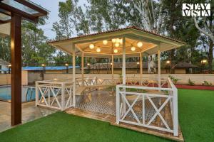 a gazebo with a table and chairs under it at Elegant Escapes with Swimming Pool, Lawn & Bonfire at Panchgani by StayVista in Panchgani