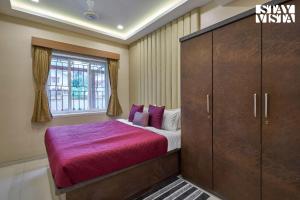 a bedroom with a bed and a large wooden cabinet at Elegant Escapes with Swimming Pool, Lawn & Bonfire at Panchgani by StayVista in Panchgani +19 photos