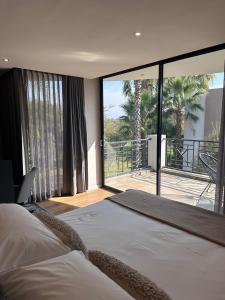 ein Schlafzimmer mit einem großen Bett und einem großen Fenster in der Unterkunft The Lakes Boutique Lodge in Pretoria