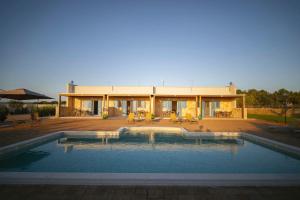 a house with a swimming pool in front of it at Dimore degli Ulivi in Leporano