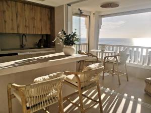 a kitchen with chairs and a counter with a view of the ocean at eme de Maison - luxury only two in Arenales del Sol