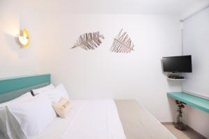 ein Schlafzimmer mit einem Bett und einem Fernseher an der Wand in der Unterkunft Blue Sand Apartment in Pefkohori