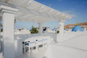 pérgola blanca con mesa y sillas en Villa Ananda - Luxury Villa in Bahiazul, en Corralejo