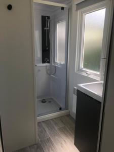 łazienka z prysznicem, umywalką i oknem w obiekcie mobil-home 4/6 pers w mieście Pont-Aven