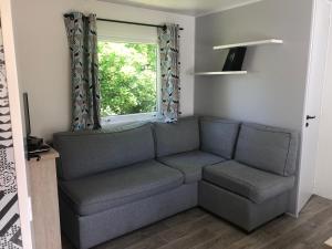 salon z kanapą i oknem w obiekcie mobil-home 4/6 pers w mieście Pont-Aven