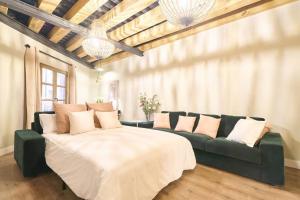a living room with a large bed and a couch at El capricho Balcón en la Plaza Mayor Salamanca Collection Luxury in Salamanca