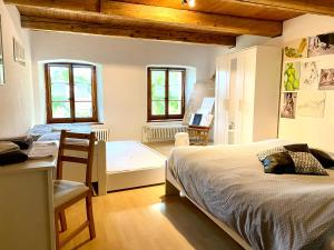 una camera da letto con un letto, un tavolo e una scrivania di Café du Soleil a Saignelégier