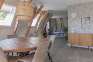 a dining room with a wooden table and chairs at Gezellig appartement in Burum