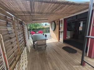 a wooden deck with a table and chairs on it at Chalet EVIDENCE CASTELJALOUX in Casteljaloux