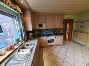 a kitchen with a sink and a stove top oven at Ferienwohnung Am Gillrather Hof in Geilenkirchen +4 photos