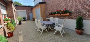 a table and chairs on a patio with flowers at Ferienwohnung Am Gillrather Hof in Geilenkirchen