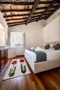 une chambre avec un lit et deux fleurs sur un tapis dans l'établissement Domus in Lauro, à Rome