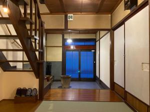 um corredor com uma escada e uma porta para um quarto em Atagoya em Takayama