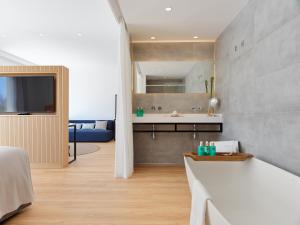 a bathroom with a tub and a sink in a room at Hotel Saratoga in Palma de Mallorca