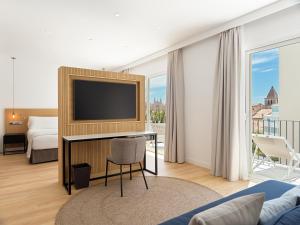 a hotel room with a television and a bed at Hotel Saratoga in Palma de Mallorca