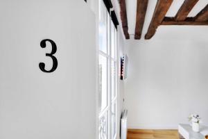 ein Zimmer mit einer Nummer an der Wand in der Unterkunft Charming studio A-C - 2P - Le Marais in Paris