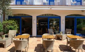 a patio with tables and chairs in front of a building at Hotel Blaumar Cadaqués by Fimedhotels in Cadaqués