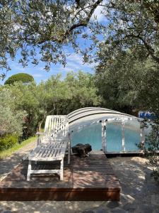 a white bench sitting next to a swimming pool at Casa Aziza , le charme andalou in Lanjarón