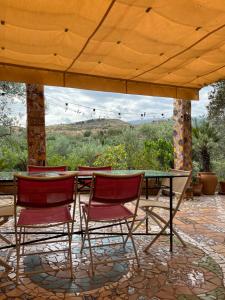 a group of chairs and a glass table on a patio at Casa Aziza , le charme andalou in Lanjarón