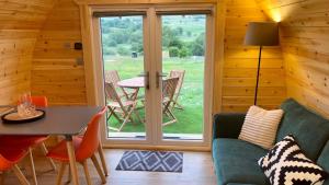 a living room with a table and chairs and a window at MTB Jumps View Pod in Trawsfynydd +13 photos