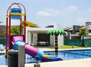 einem Pool mit Wasserrutsche vor einem Haus in der Unterkunft Casa Moderna Frente Alberca 3 min de la Playa Azul Pacifico in Mazatlán