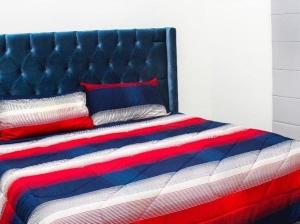 ein Bett mit einer roten weißen und blauen Decke in der Unterkunft Casa Moderna Frente Alberca 3 min de la Playa Azul Pacifico in Mazatlán