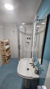 a bathroom with a white sink and a shower at Apartamento Faro Burela in Burela de Cabo