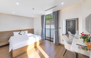 a bedroom with a large bed and a desk and chairs at Green LP Hotel & Apartment in Vung Tau