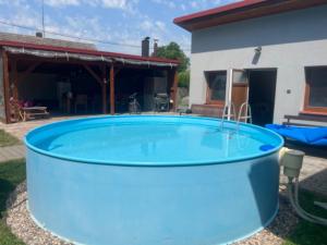 a large blue pool in front of a house at Chata Nový Ples in Nový Ples