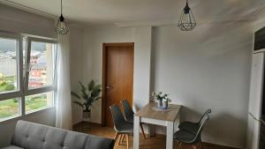 a living room with a table and chairs at Apartamento Faro Burela in Burela de Cabo